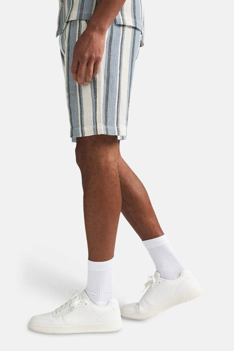 Kort blauw gestreept van Petrol Industries, gedragen met witte sokken en witte sneakers, in zijaanzicht.