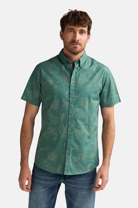 Chemise verte à manches courtes de Petrol Industries®, imprimée de motifs floraux, portée avec un jean bleu