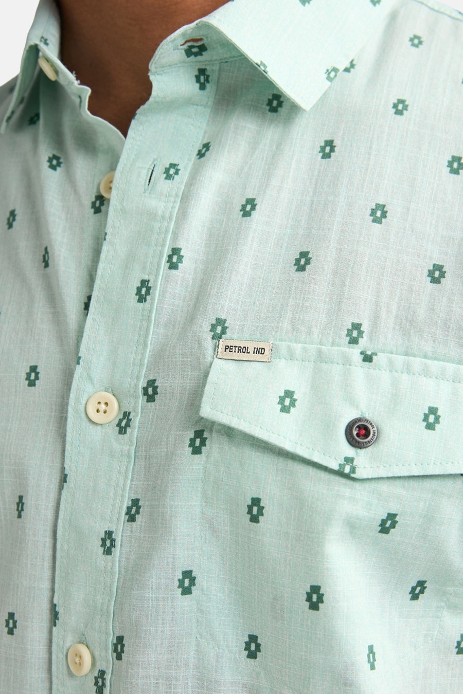 Chemise à manches courtes verte de Petrol Industries avec motif à croix et poche de poitrine boutonnée.