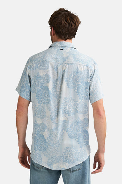Blauw overhemd met korte mouwen van Petrol Industries® met blauwe bloemenprint en stippenstructuur, van achteren gedragen met een lichte spijkerbroek.