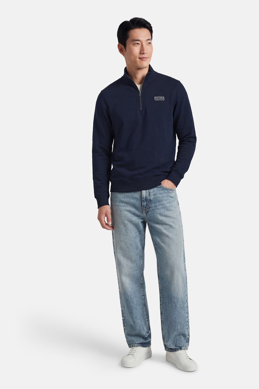 Sweat bleu Petrol Industries®, avec fermeture éclair au col, porté avec un jean décontracté et des baskets blanches.