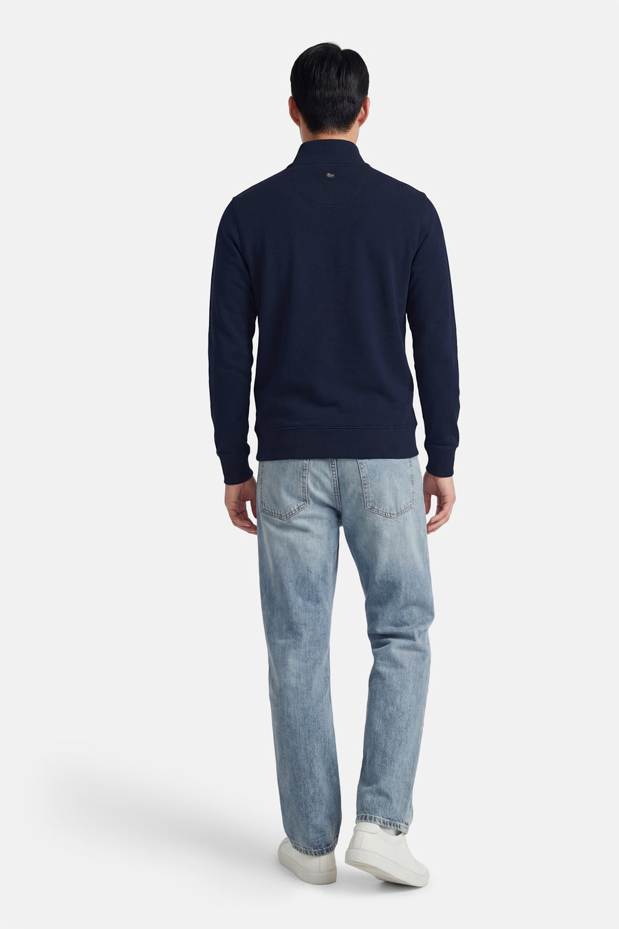 Sweat bleu de Petrol Industries®, porté avec un jean clair et des chaussures de sport blanches, vue de dos.