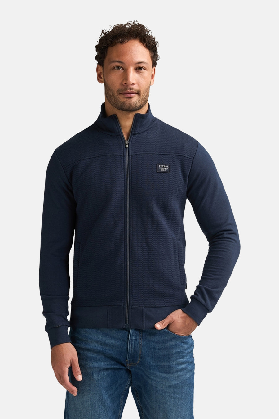 Blauwe sweater met opstaande kraag van Petrol Industries®, textuurdetail aan de bovenkant, gedragen met een spijkerbroek en witte sneakers, achterzicht.