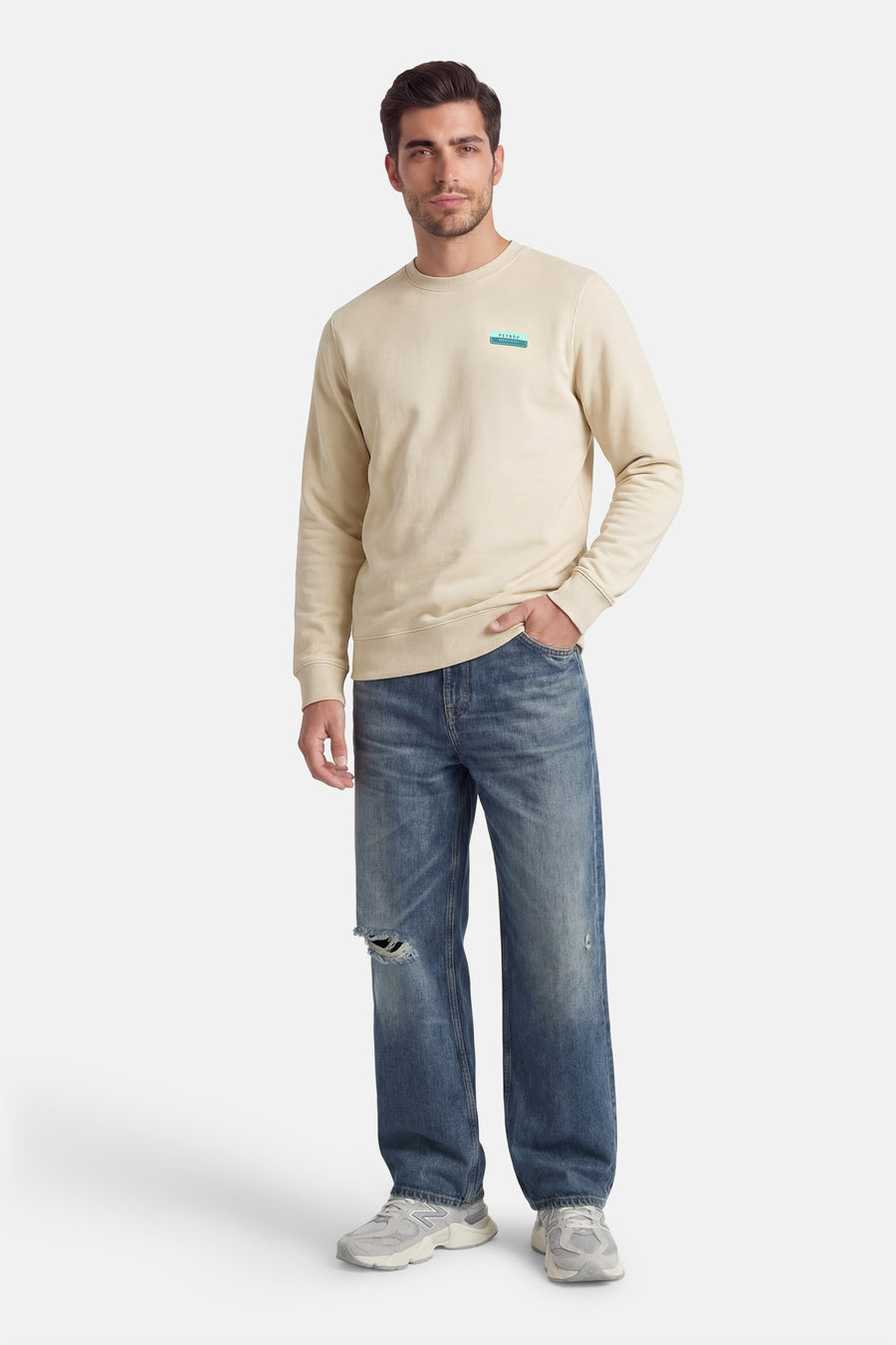 Sweat-shirt écru de Petrol Industries, avec logo sur la poitrine, porté avec un jean bleu délavé et des baskets.