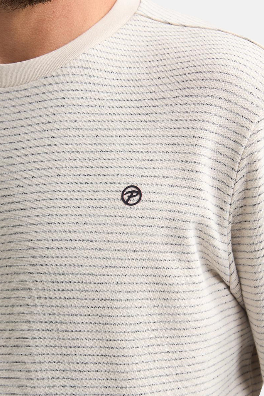 Pull à col rond écru de Petrol Industries®, rayé horizontalement, avec un logo sur la poitrine.