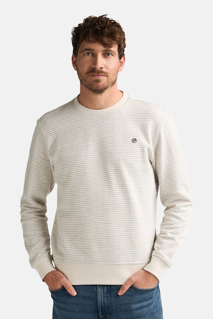 Pull à col rond écru de Petrol Industries® avec motif rayé horizontal et texture tricotée, porté avec un jean bleu.