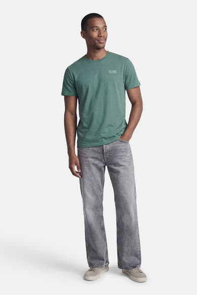 T-shirt à manches courtes vert de Petrol Industries®, porté avec un jean gris délavé et des baskets beiges.