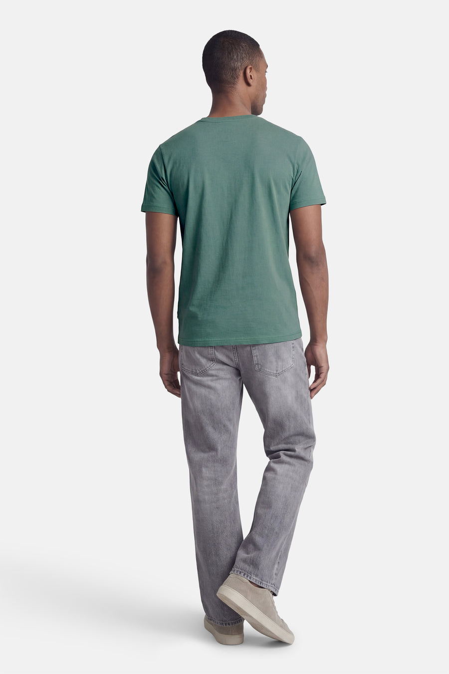 Groen T-shirt met korte mouwen van Petrol Industries®, gedragen met een grijze broek en crèmekleurige sportschoenen, achtergezicht.