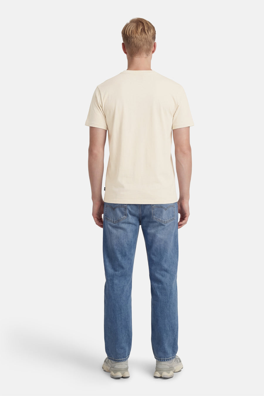 T-shirt à manches courtes écru de Petrol Industries®, porté avec un jean bleu et des baskets grises, vue de dos.