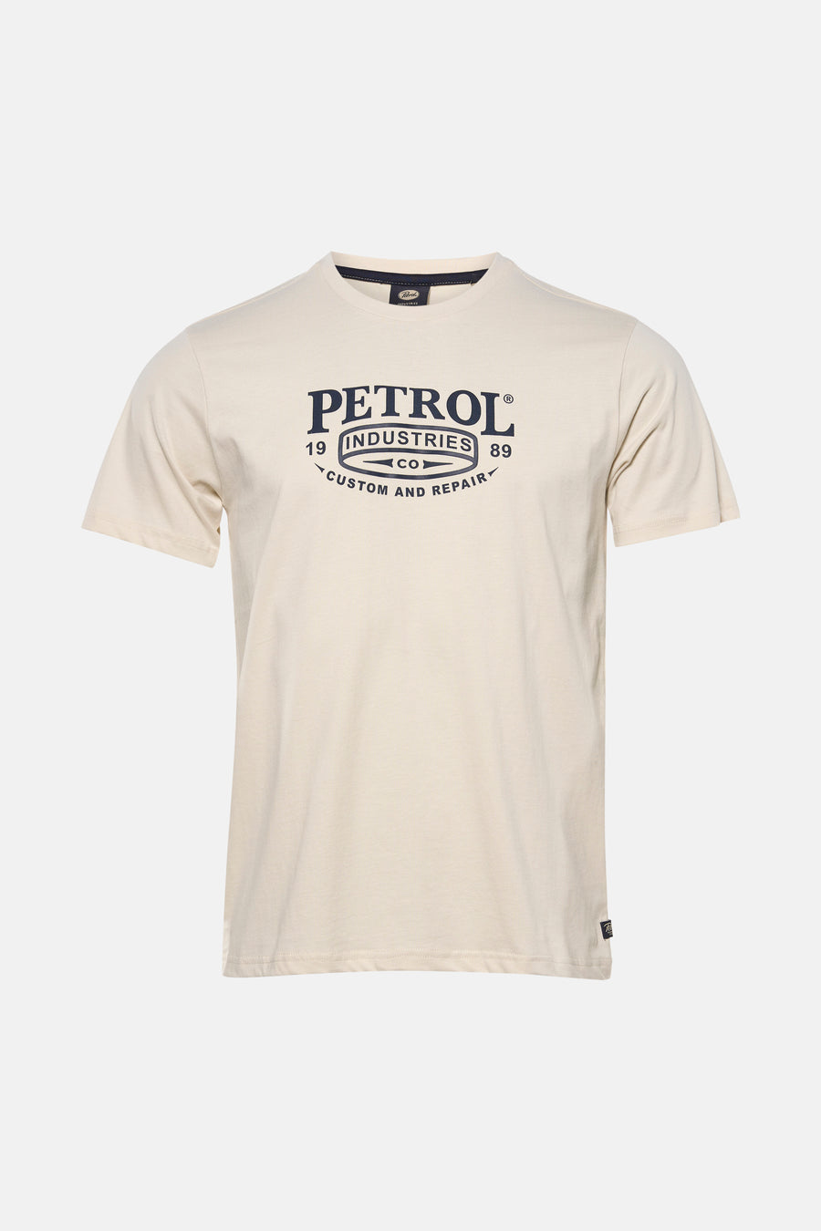 Ecru T-shirt met korte mouwen van Petrol Industries, met een grafische print op de voorkant, gedragen met een grijze jeans en sneakers.