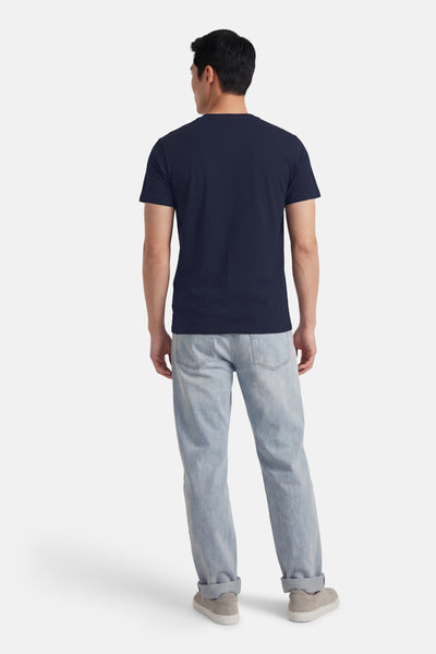 T-shirt à manches courtes bleu de Petrol Industries, porté avec un jean clair et des chaussures en daim gris, vue de dos.