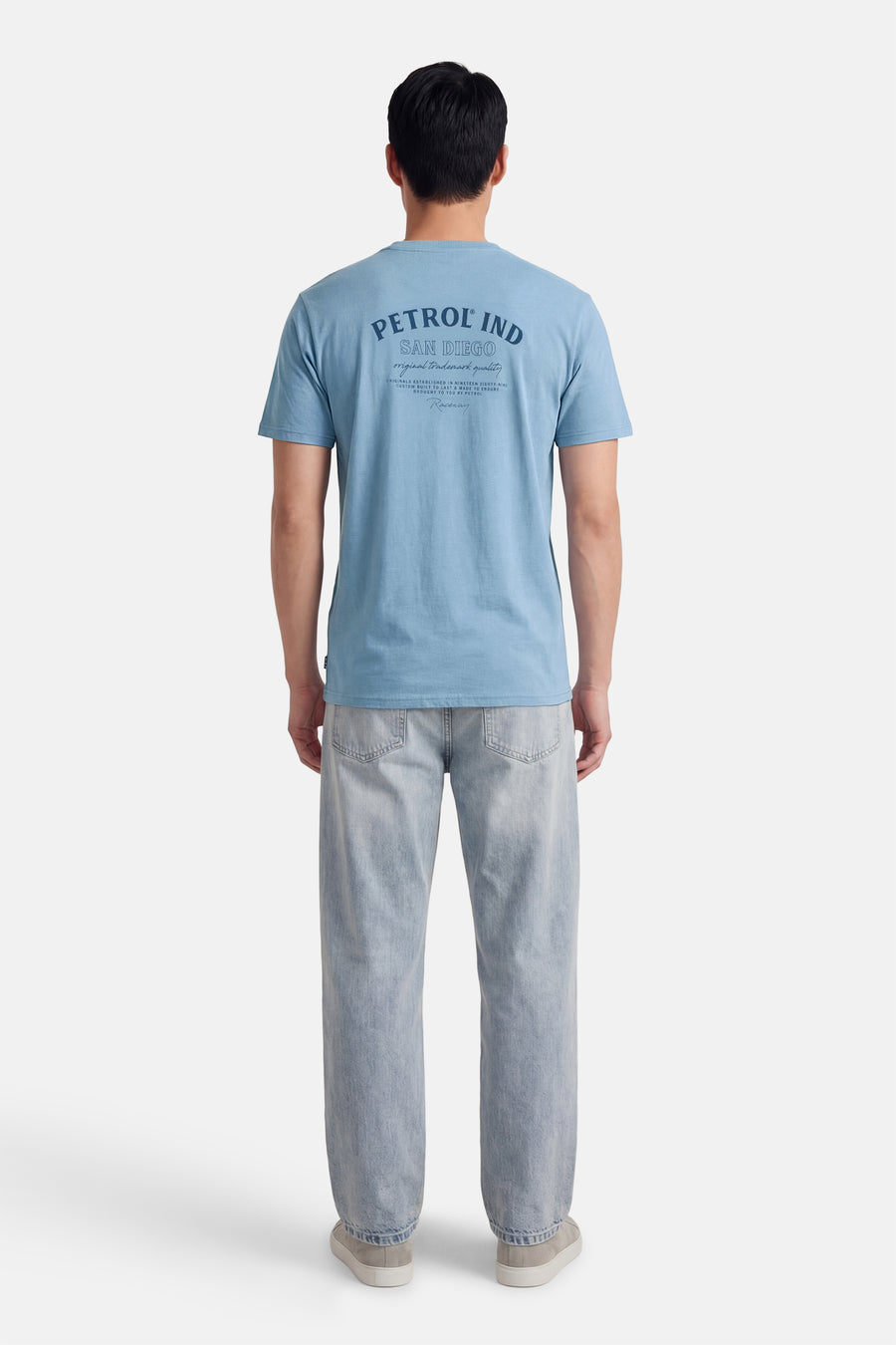 T-shirt bleu à manches courtes de Petrol Industries®, avec un imprimé sur le dos, porté avec un jean décontracté.