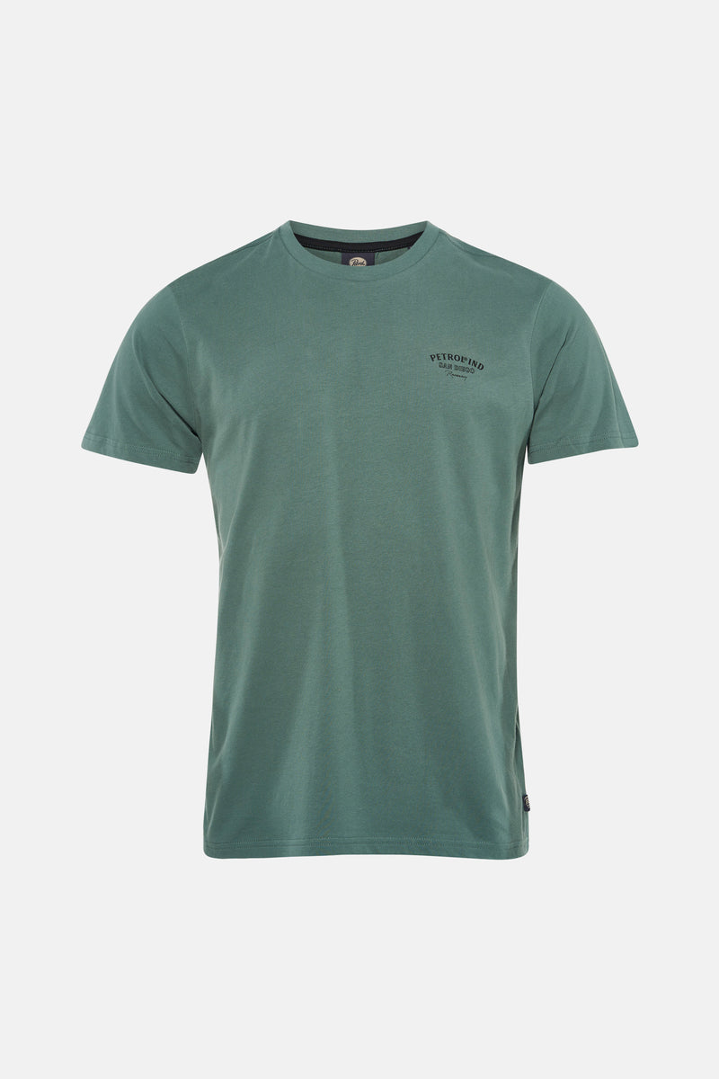 Groen T-shirt met korte mouwen van Petrol Industries, met een zwarte print op de rug, gedragen met een verbleekte spijkerbroek.