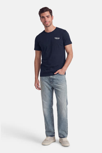 T-shirt à manches courtes bleu de Petrol Industries®, porté avec un jean délavé et des baskets blanches.