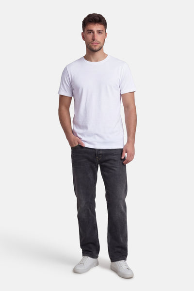 T-shirt blanc à manches courtes de Petrol Industries®, porté avec un jean délavé et des baskets blanches.