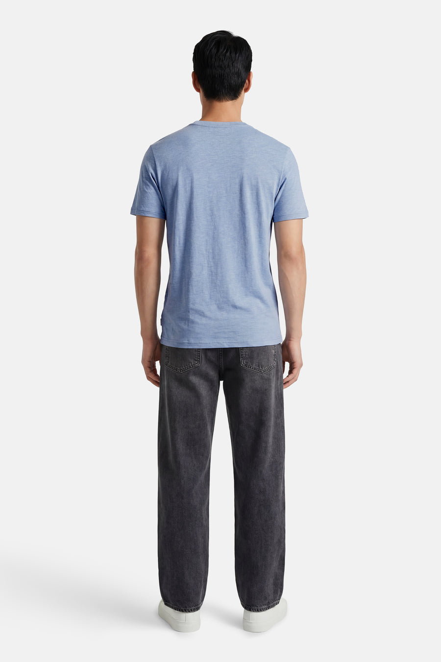 Blauw T-shirt met korte mouwen van Petrol Industries®, van achteren gezien, gedragen met een donkergrijze jeans en witte schoenen.
