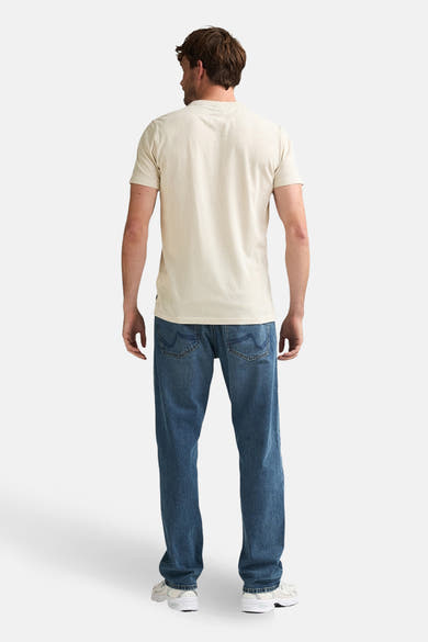 Beige T-shirt met korte mouwen van Petrol Industries®, gedragen met een blauwe jeans en witte sneakers, achtergezicht.
