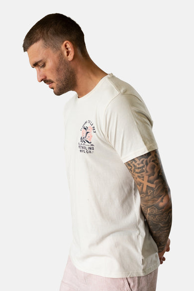 Ecru T-shirt met korte mouwen van Petrol Industries®, met opdruk op de rug en gedragen met een roze short.
