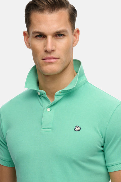 Groen SUPERDRY poloshirt met kraag en knoopsluiting, versierd met een discreet logo.