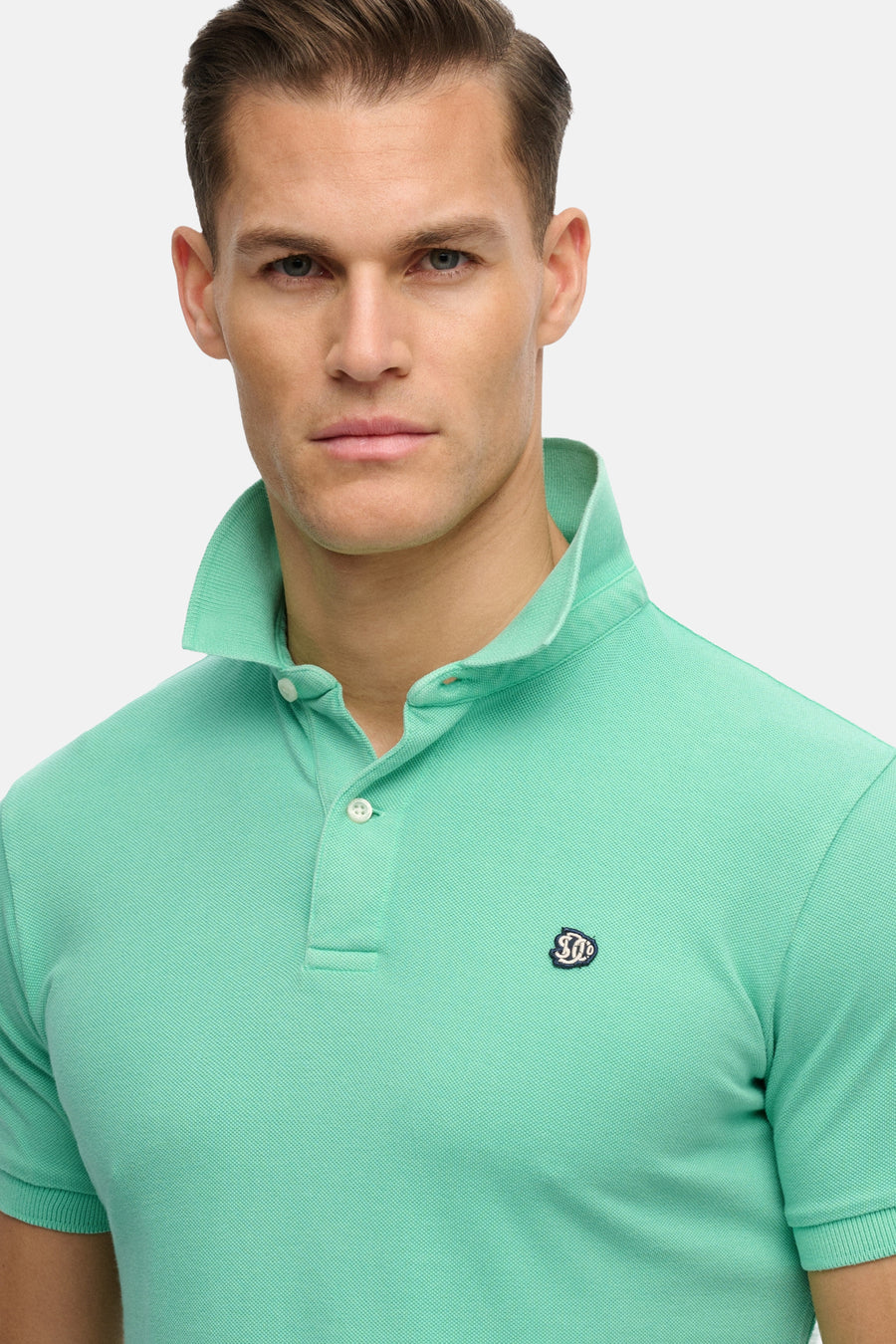 Groen SUPERDRY poloshirt met kraag en knoopsluiting, versierd met een discreet logo.
