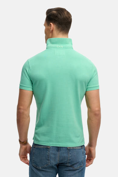 Polo vert par SUPERDRY, vue de dos, porté avec un jean bleu.