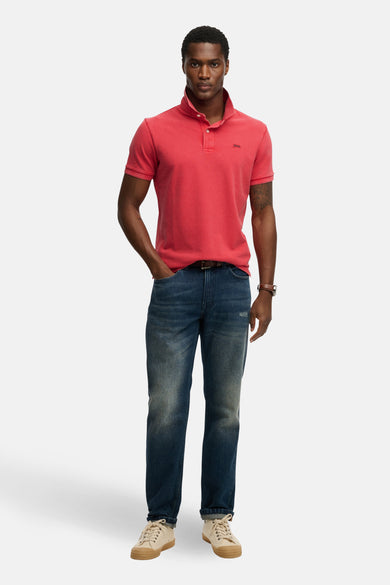 Roze poloshirt met korte mouwen van SUPERDRY, gedragen met een blauwe spijkerbroek en crèmekleurige schoenen.