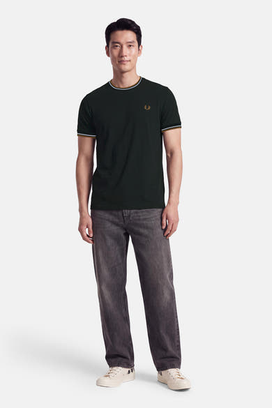 T-shirt à manches courtes kaki FRED PERRY porté par un homme, avec col et bordures de manches rayés.
