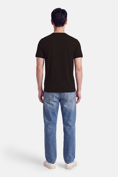 Vue de dos d’un homme portant un T-shirt à manches courtes brun FRED PERRY et un jean bleu.