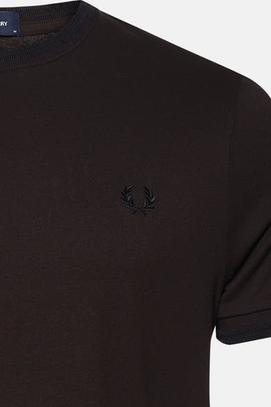 Détail d’un T-shirt à manches courtes brun FRED PERRY avec col rond, manches bordées et logo brodé.