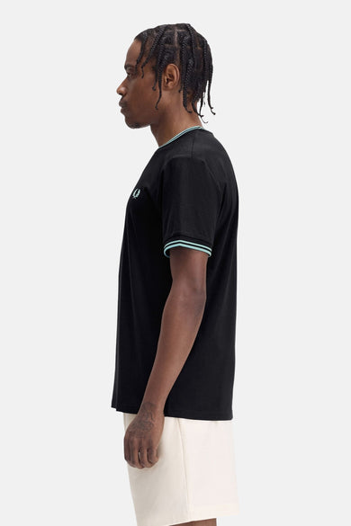 T-shirt noir à manches courtes de Fred Perry, orné d'un liseré bleu clair au col et aux manches.