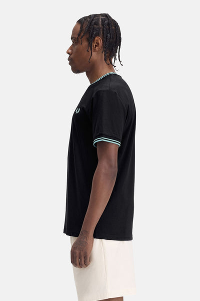 T-shirt noir à manches courtes de Fred Perry, orné d'un liseré bleu clair au col et aux manches.