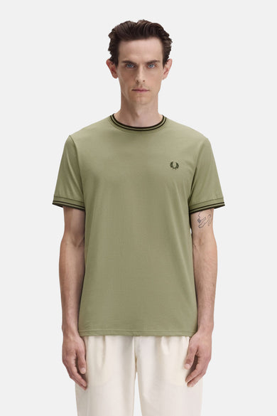 T-shirt olive à manches courtes de Fred Perry avec col et bordures de manches rayés.