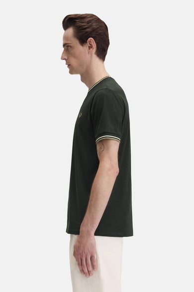 T-shirt à manches courtes vert de FRED PERRY, col et manches rayés, porté par un homme de profil.