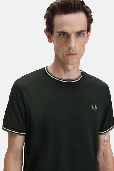 T-shirt vert à manches courtes de Fred Perry avec col et bordures de manches rayées.