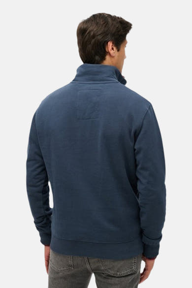 Blauwe sweater met opstaande kraag van SUPERDRY, achterkant, met discrete patch bovenaan de rug.