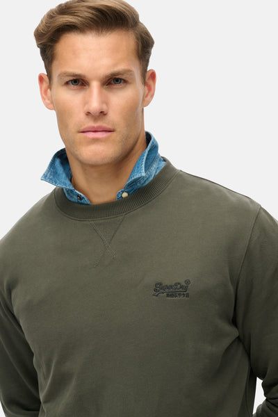 Kaki sweatshirt met ronde hals van Superdry, gedragen over een lichtblauw spijkerhemd.