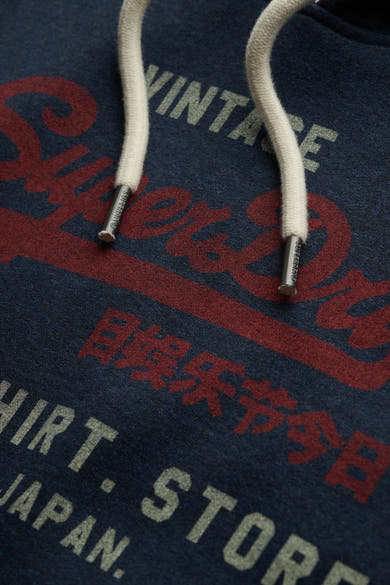 Sweat à capuche bleu de SUPERDRY avec cordon blanc et lettrage rouge et gris.
