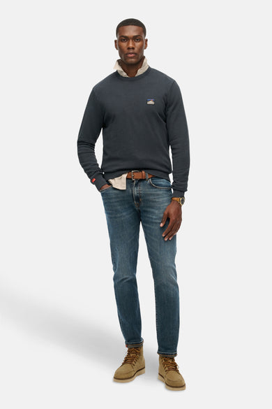 Blauwe trui van SUPERDRY, gedragen over een beige overhemd met een spijkerbroek en bruine laarzen
