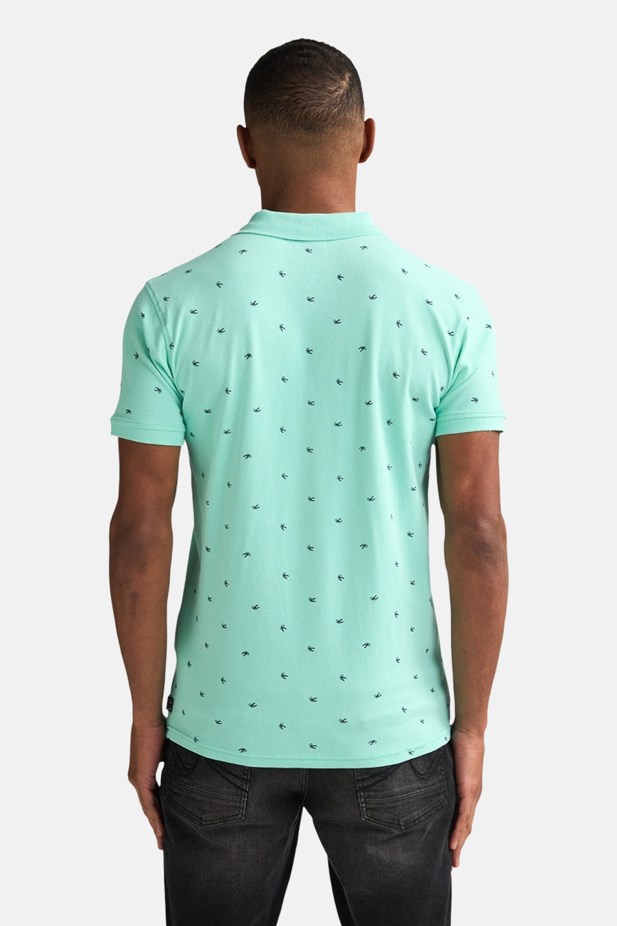 Licht muntgroen poloshirt van Petrol Industries met kleine donkere zeemotieven, van achteren gezien.