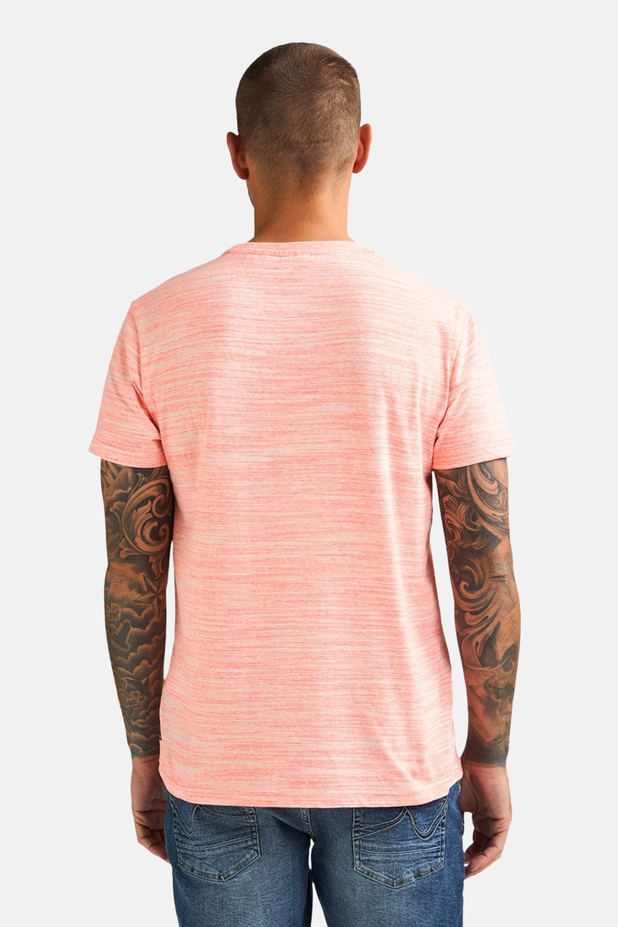 Koraalkleurig T-shirt met korte mouwen van Petrol Industries, met een gemêleerd patroon, gedragen met een spijkerbroek.