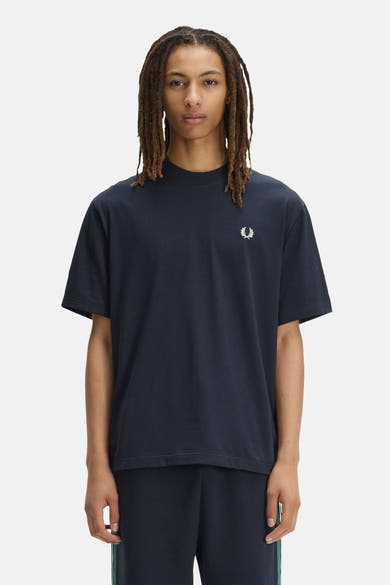 Blauw T-shirt van FRED PERRY met opstaande kraag, versierd met een geborduurd wit lauriertaklogo op de borst.