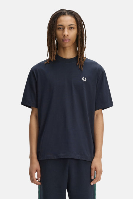 Blauw T-shirt van FRED PERRY met opstaande kraag, versierd met een geborduurd wit lauriertaklogo op de borst.