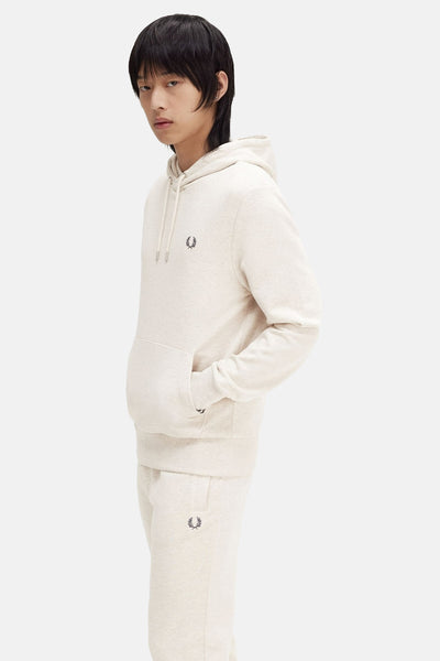 Beige hoodie van Fred Perry, met een strakke band en geborduurd logo op de borst, gedragen met een passende bro.