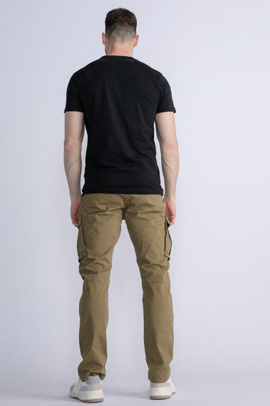 Groene cargobroek van Petrol Industries®, gedragen met een zwart T-shirt en witte sneakers, achterzijde.