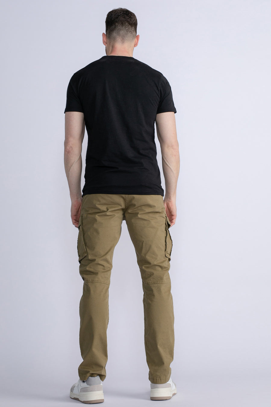 Groene cargobroek van Petrol Industries®, gedragen met een zwart T-shirt en witte sneakers, achterzijde.