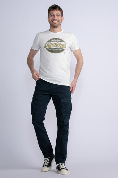 Blauwe cargobroek van Petrol Industries, gedragen met een wit T-shirt met print en zwart-witte sneakers.