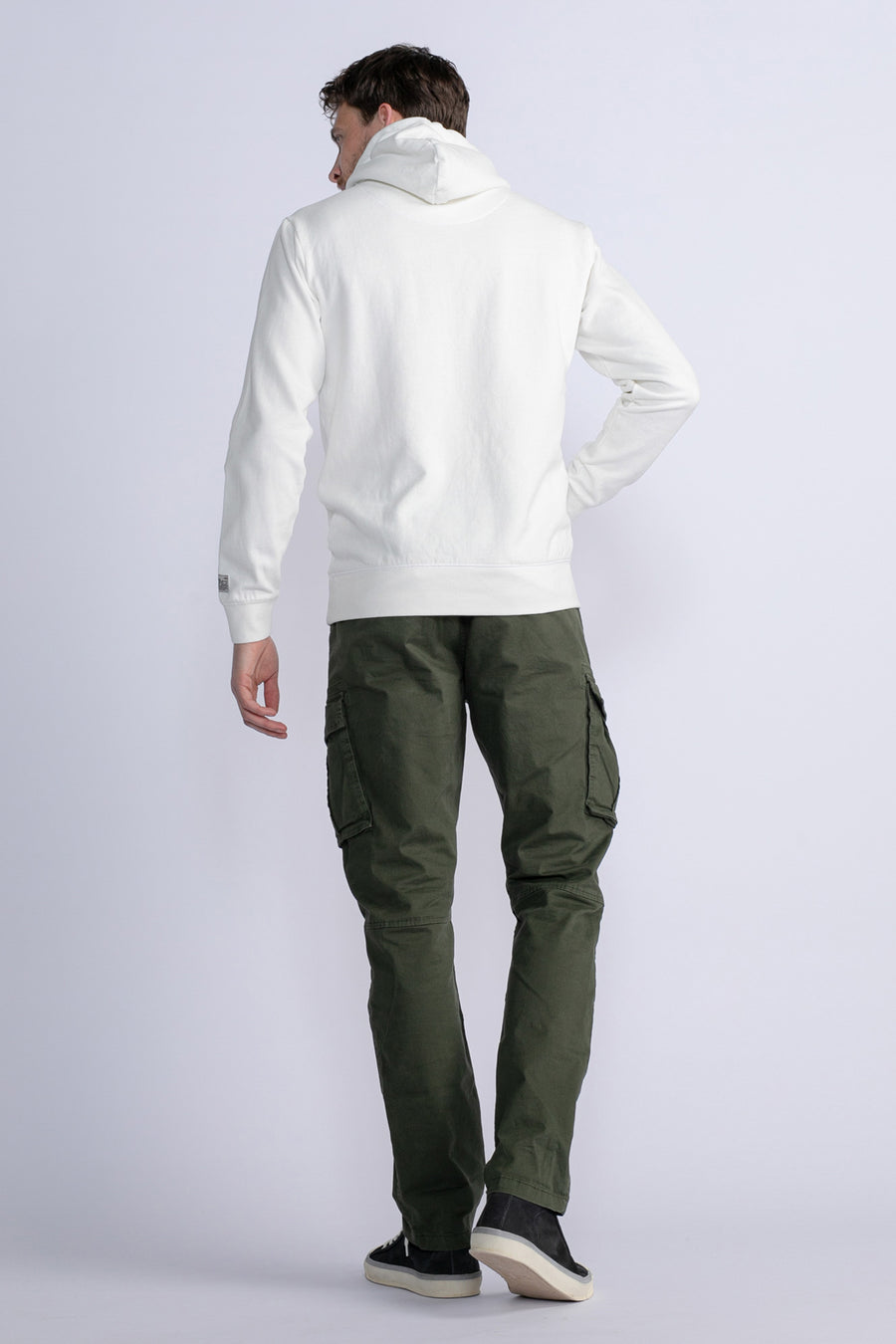 Groene cargobroek van Petrol Industries, gedragen met een witte hoodie en zwarte schoenen.