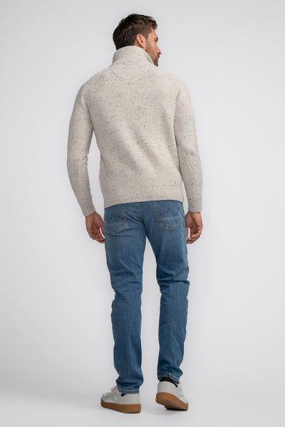 Pull à col roulé écru de Petrol Industries, en maille texturée, porté avec un jean bleu.