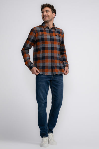 Chemise à manches longues à carreaux, cognac de Petrol Industries®, portée avec un jean et des baskets blanches.
