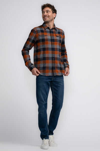 Chemise à manches longues à carreaux, cognac de Petrol Industries®, portée avec un jean et des baskets blanches.